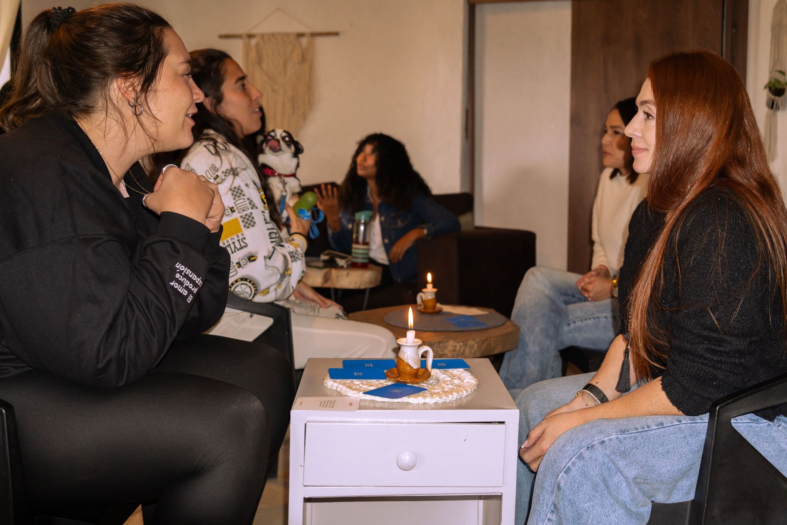 Personas conversando alrededor de una mesa con una vela
